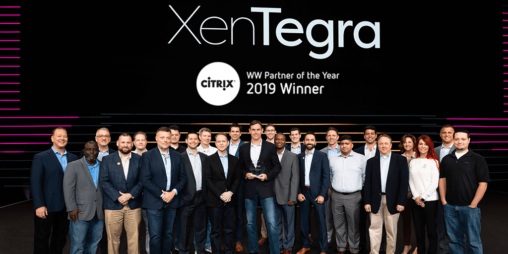 XenTegra team standing on stage in front of a large screen displaying "XenTegra" and "Citrix WW Partner of the Year 2019 Winner"