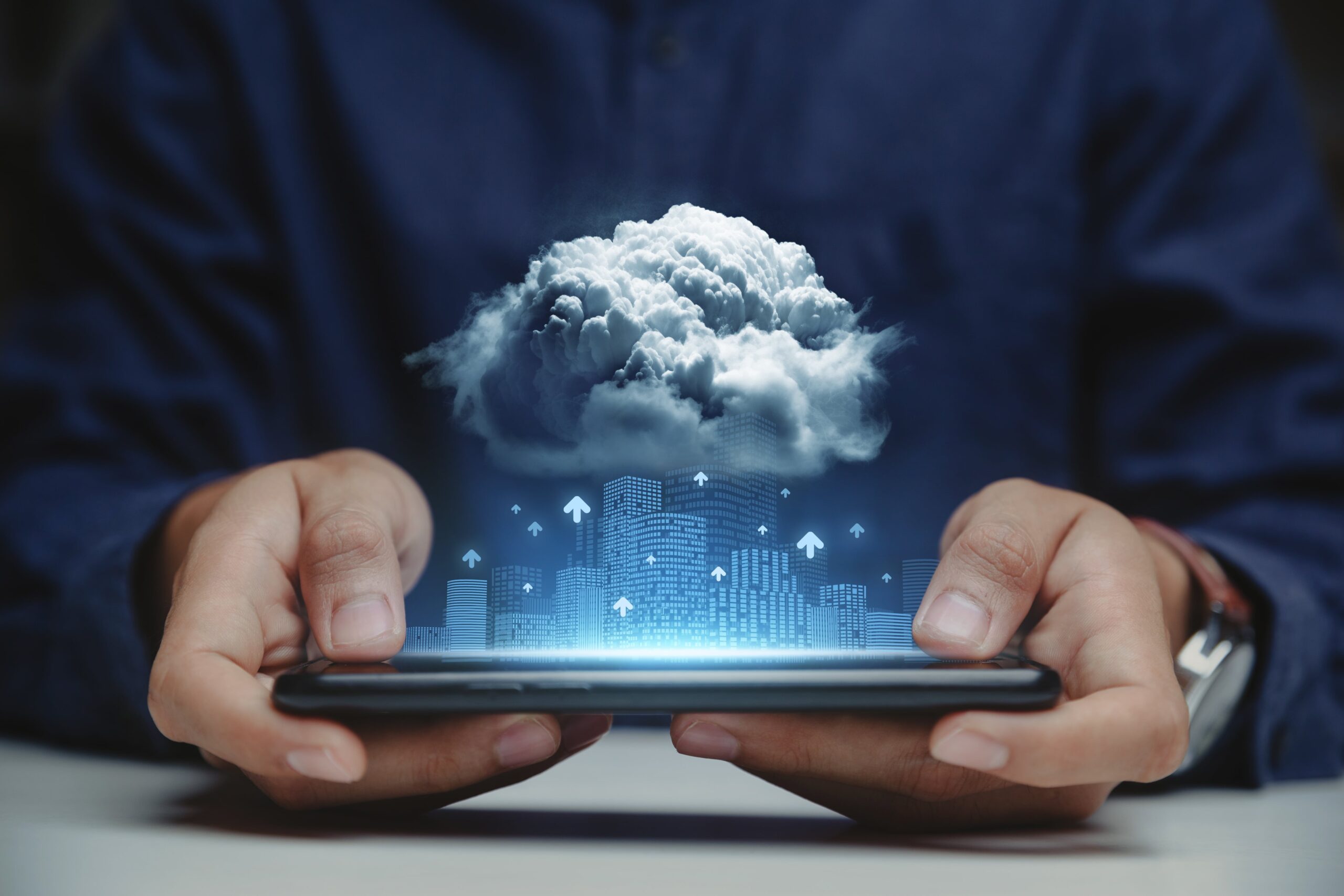 a person holding their phone horizontally for a hologram of tall buildings with a giant cloud above them