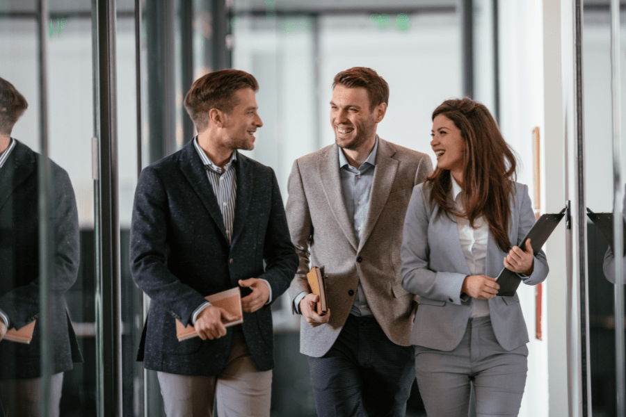 three people walking and talking in an office