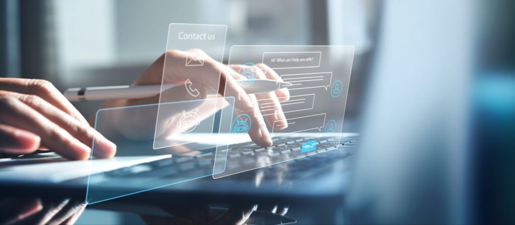 Hands typing on a laptop with overlay graphics showing digital icons for IT services